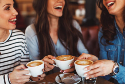 Home three young women enjoy coffee at a coffee shop
